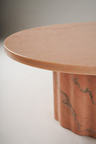 Stine Coffee Table 01 – side angle showing fluid sculpted base in Rosa Aurora marble