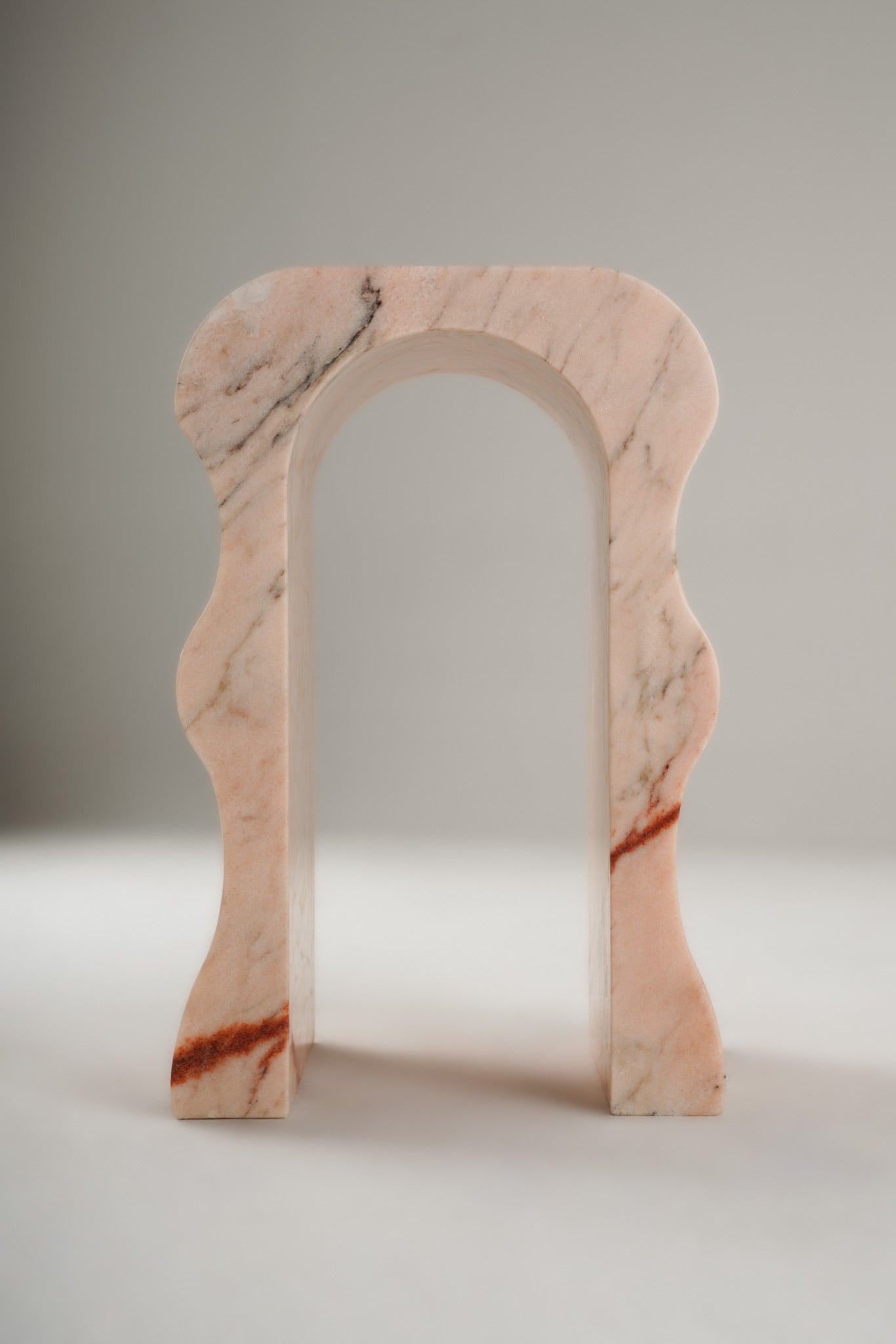 Stine Stool 01 in Rosa Aurora marble – curved sculptural legs, front view
